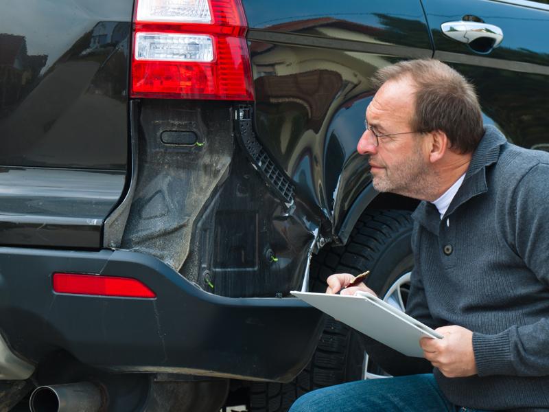 Mechaniker untersucht Unfallschaden.